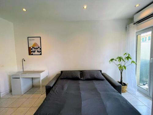 une chambre avec un grand lit et un bureau dans l'établissement Joli appartement au bord de mer, à Nice