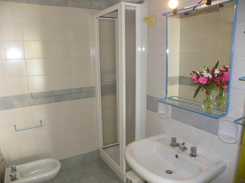 a bathroom with a sink and a vase of flowers at Estella Club in Montepaone