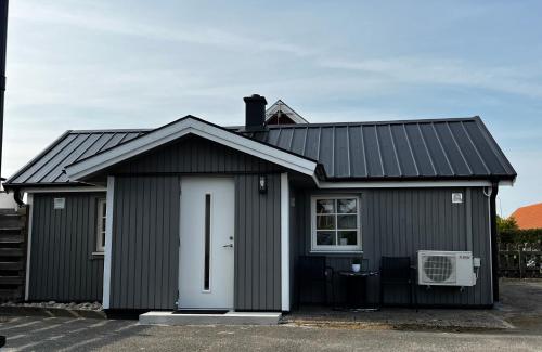 a black house with a white door at Stuga Loft Apartment Rinkaby-Åhusvägen 
