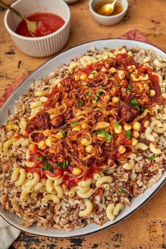 a plate of food with pasta and sauce on a table at بيت الريف المصرى 