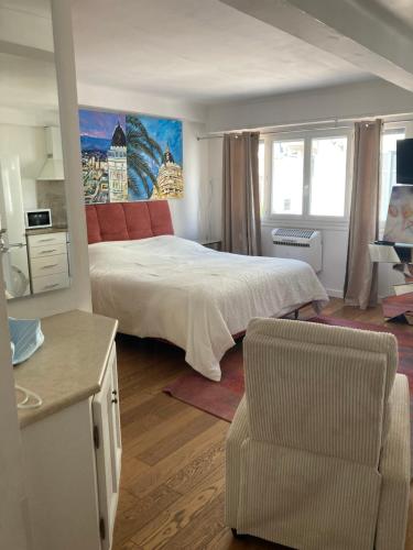 une chambre avec un grand lit et une chaise dans l'établissement Très beau studio centre Cannes, 600m de la Croisette, à Cannes