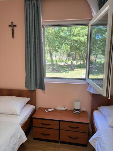 a small room with two beds and a window at Casa Del Pellegrino M&A - Ostojići in Međugorje