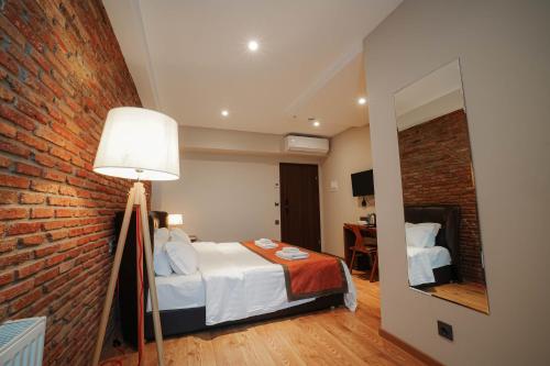 a bedroom with a bed and a brick wall at Boutique Hotel Kviria in Tʼelavi