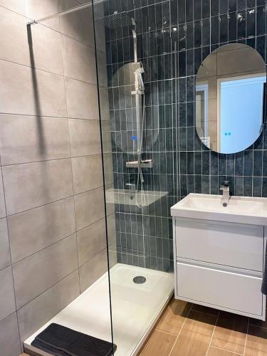 une douche avec une porte vitrée dans une salle de bain dans l'établissement Joli appartement au bord de mer, à Nice