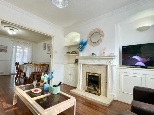 a living room with a fireplace and a tv at Lavender Dream House in Evesham