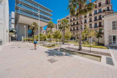 a man walking through a plaza in a city at Ô Repos des artistes - Balcon & Spa in Toulon