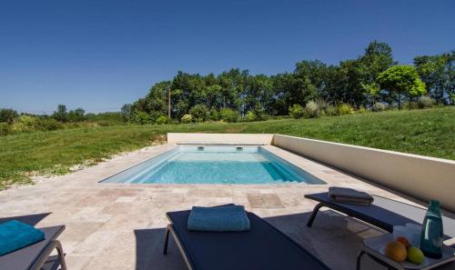 une piscine avec deux chaises et une table dans l'établissement La Chênaie, à Montauriol