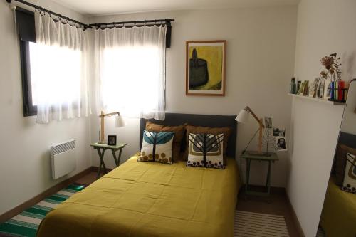 une chambre avec un lit avec une couverture jaune dans l'établissement La Chênaie, à Montauriol