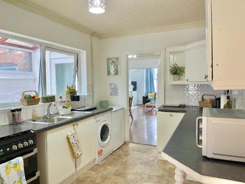a kitchen with a sink and a washing machine at Lavender Dream House in Evesham