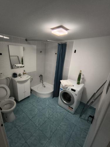 a bathroom with a toilet a sink and a washing machine at Casa Tesmao in Constanţa