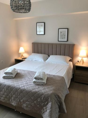 ルートラ・オレアス・エレニスにあるVilla Kleopatraの大きなベッドとタオル2枚のある寝室