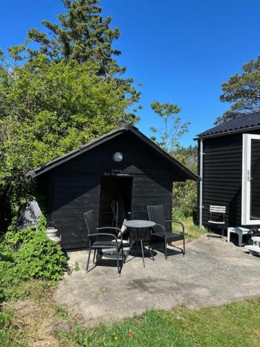 a black building with a table and chairs in it at Rødhus Gl. Skole B&B in Pandrup