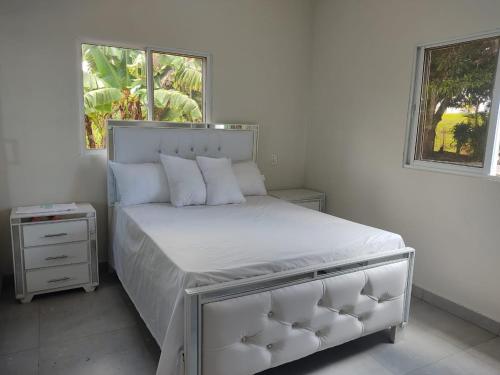 a bedroom with a bed with white sheets and pillows at Hermosa Casa en Juana Vicenta Samana in Santa Bárbara de Samaná