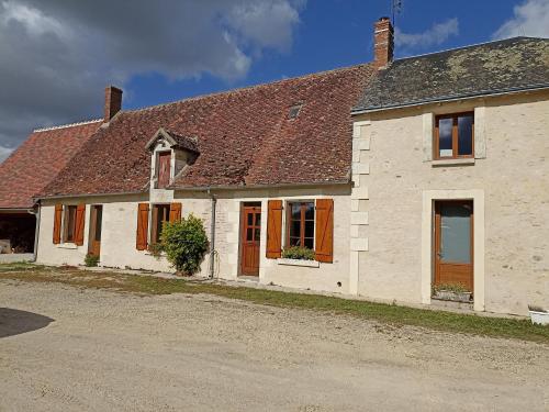 une maison blanche avec un toit marron dans l'établissement Maison de campagne en brenne, à Saulnay