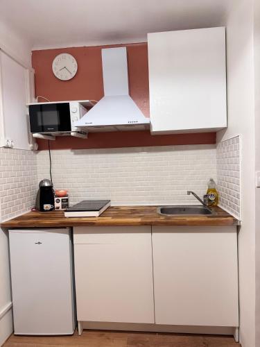 une cuisine avec des armoires blanches et un comptoir dans l'établissement Les Jonquilles, à Marseille