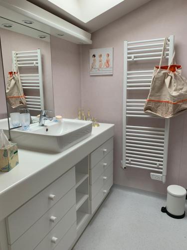 une salle de bain avec un lavabo et un miroir dans l'établissement Myfamily, à Capbreton