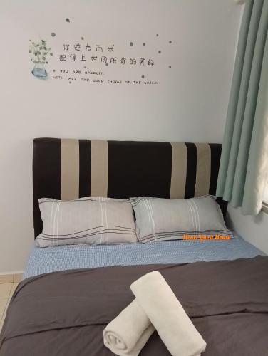 a bed with a towel on top of it at Heart Bentong Guest House 文冬心宿民宿 Bentong Homestay in Bentong