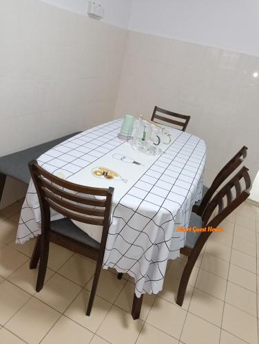 a dining room table with a white tablecloth and two chairs at Heart Bentong Guest House 文冬心宿民宿 Bentong Homestay in Bentong