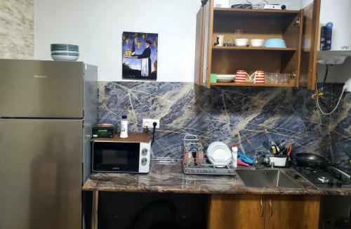 a kitchen counter with a microwave and a refrigerator at old kutaisi in Kutaisi