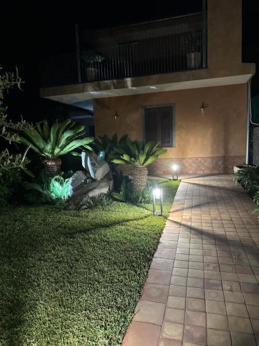 a walkway in front of a building at night at La Dimora degli ulivi in SantʼAlfio