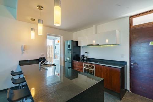 a kitchen with a black counter top and wooden cabinets at Papaya 15 Apartments in Playa del Carmen