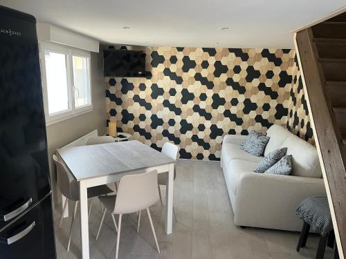 un salon avec une table et un canapé dans l'établissement Maison atypique Les Venages, à Naveil