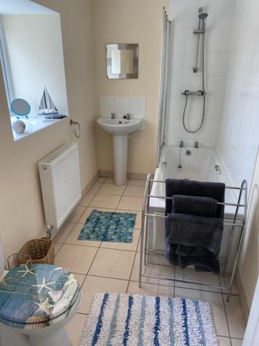 a bathroom with a tub and a sink and a toilet at Swallow Bach in Llanddyfnan