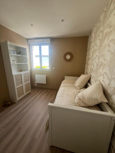 une chambre avec un lit blanc et une fenêtre dans l'établissement Maison atypique Les Venages, à Naveil