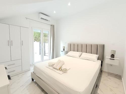 - une chambre blanche avec un lit et 2 téléphones dans l'établissement Sueno de luz Corfu, à Áfra