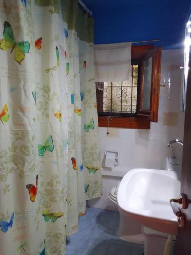 un bagno con tenda doccia con farfalle di Perky Roses Home, Mountain Meets Sea in Milies, Pelion a Miléai