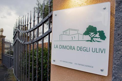 a sign on a fence in front of a building at La Dimora degli ulivi in SantʼAlfio