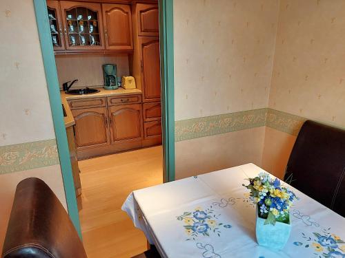 a table with a vase of flowers on it at Villa Lindenhof in Bad Elster