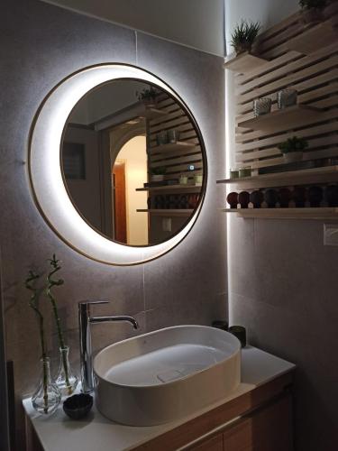 a bathroom with a sink and a round mirror at Konitsa Primula in Konitsa