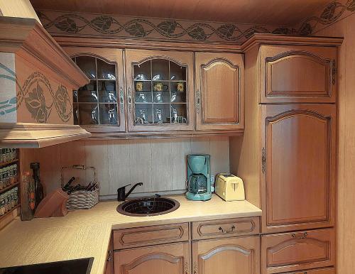 a kitchen with wooden cabinets and a blender at Villa Lindenhof in Bad Elster