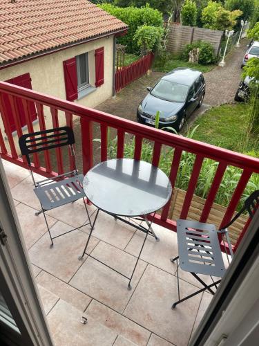 a table and chairs on a balcony with a car at Appartement proche gare in Tonneins