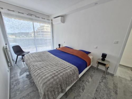 une chambre avec un lit, une fenêtre et une chaise dans l'établissement Incroyable vue sur des Îles, à Antibes