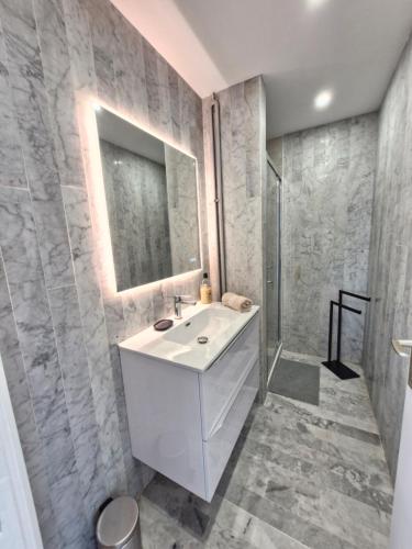 une salle de bain avec un lavabo blanc et une douche dans l'établissement Incroyable vue sur des Îles, à Antibes