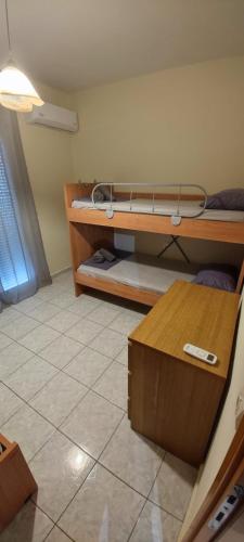 a room with two bunk beds and a table at Stella apartments in Olympiaki Akti