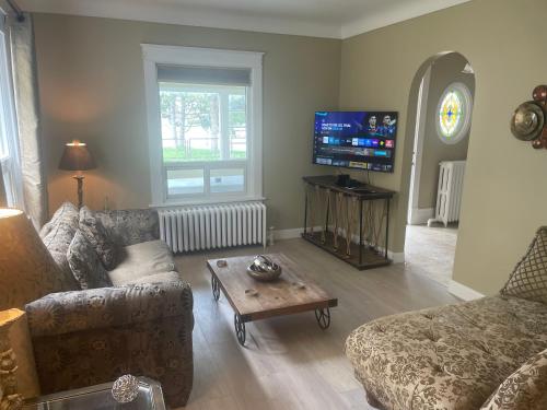 a living room with a couch and a coffee table at Ultra Close to Clifton Hill and the Falls & Wonderful Free Breakfast Delivered Daily in Niagara Falls
