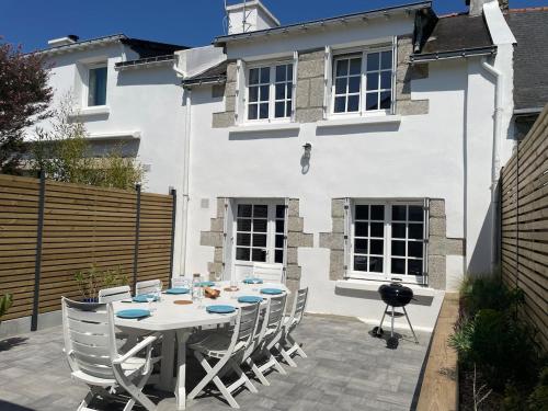 une table et des chaises devant une maison blanche dans l'établissement Ty Silin maison de vacances-600m de la plage et 400m du golf de Kerver à pied, à Saint-Gildas-de-Rhuys