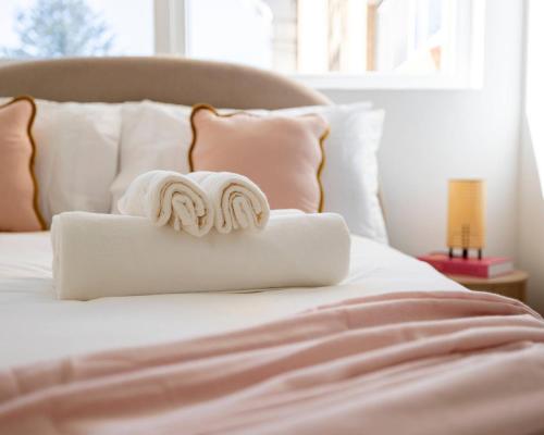 a white bed with two towels on top of it at 1 min to the beach with A/C, balcony & parking in Sydney