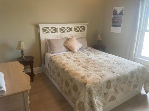 a bedroom with a white bed with two pillows at Ultra Close to Clifton Hill and the Falls & Wonderful Free Breakfast Delivered Daily in Niagara Falls