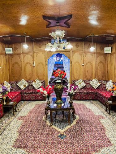 a living room with red couches and a chandelier at Honolulu Group Of Houseboats in Srinagar