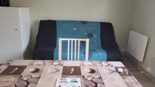 une chambre avec un lit avec un berceau avec une couverture bleue dans l'établissement Chti Picard 2 Vue latéral mer et wifi, à Berck-sur-Mer