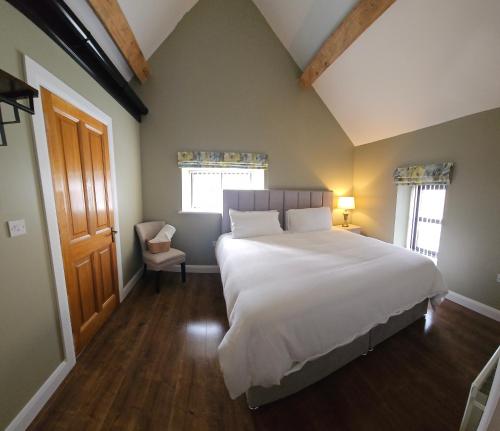 a bedroom with a large white bed and a window at The Manor Guest Accommodation Dungiven in Dungiven