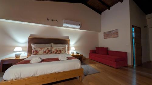 a bedroom with a bed and a red couch at Althea Apartments in Katakolon