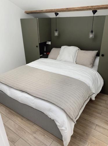 une chambre avec un grand lit avec des draps blancs dans l'établissement La Casa Familia - Plage à 10 min - Terrasse ensoleillée - 70m2, à La Teste-de-Buch