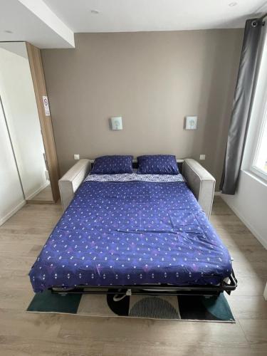 une chambre avec un lit avec des oreillers bleus dessus dans l'établissement Hyper centre! Magnifique studio à proximité directe de la gare et place morny, à Deauville