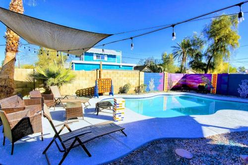 a backyard with a pool with chairs and a umbrella at Phoenix Home Pool & String Lights in Phoenix