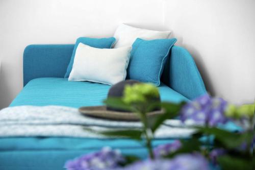 a blue couch with pillows and a hat on a table at De Pando Panoramic Suites 1096 in Scala